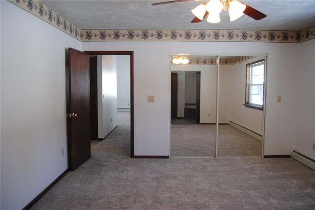 unfurnished bedroom featuring ceiling fan, a closet, and a baseboard heating unit