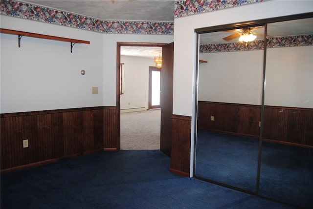 carpeted empty room featuring a baseboard radiator and ceiling fan