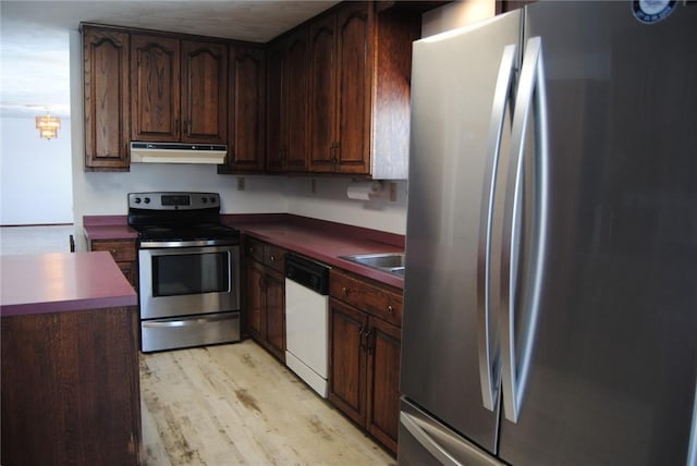 kitchen featuring dark brown cabinets, sink, light hardwood / wood-style flooring, and stainless steel appliances