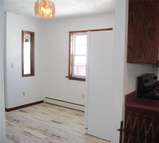 interior space with a baseboard radiator, light hardwood / wood-style flooring, and range with electric stovetop