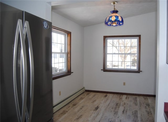 unfurnished dining area with light hardwood / wood-style flooring and a baseboard heating unit