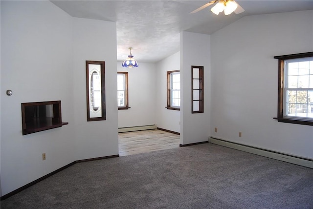 unfurnished living room with vaulted ceiling, plenty of natural light, a baseboard radiator, and light carpet