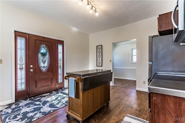 foyer entrance featuring a textured ceiling and dark hardwood / wood-style flooring