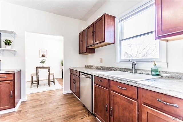 kitchen featuring sink, stainless steel dishwasher, light hardwood / wood-style flooring, and light stone countertops