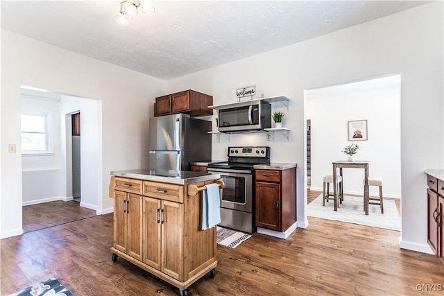 kitchen featuring a kitchen island, dark hardwood / wood-style flooring, and stainless steel appliances