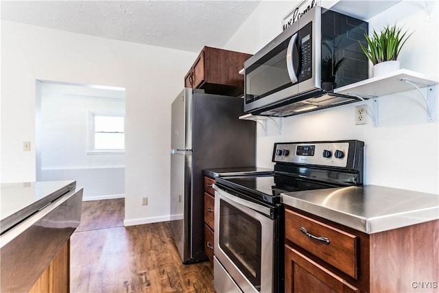 kitchen featuring dark wood-type flooring, stainless steel counters, and stainless steel appliances