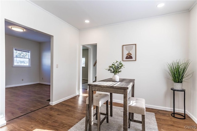 dining space with dark wood-type flooring and ornamental molding