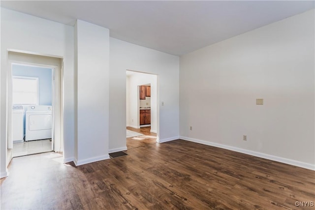 spare room with dark wood-type flooring and washing machine and dryer