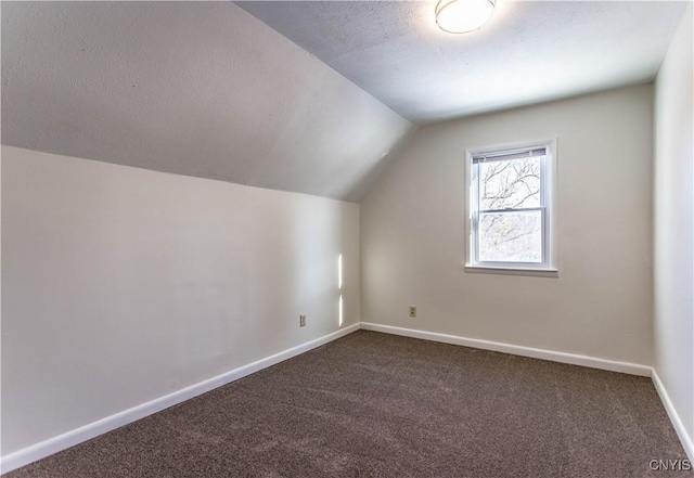 bonus room with dark carpet, a textured ceiling, and lofted ceiling