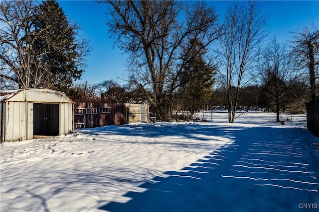 snowy yard featuring a shed