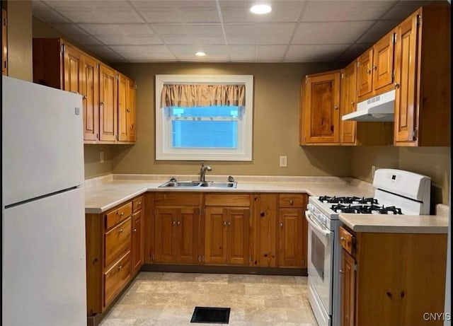 kitchen with sink, white appliances, and a drop ceiling