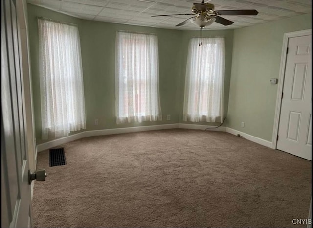 spare room featuring ceiling fan, a paneled ceiling, and carpet flooring