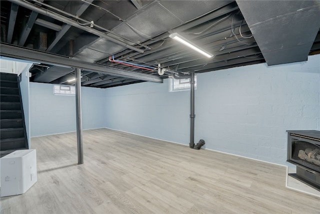 basement with hardwood / wood-style floors and a wood stove