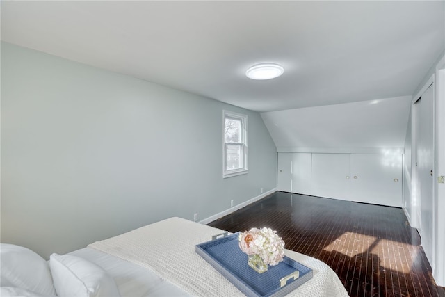 bedroom featuring wood-type flooring and lofted ceiling