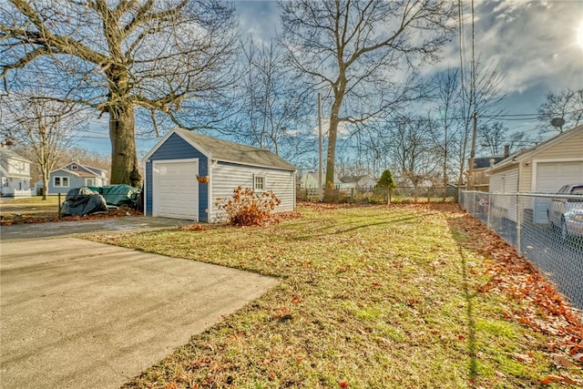 view of yard with a garage and an outbuilding