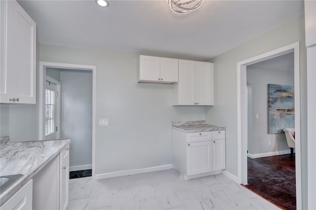 kitchen with sink, white cabinetry, and light stone countertops