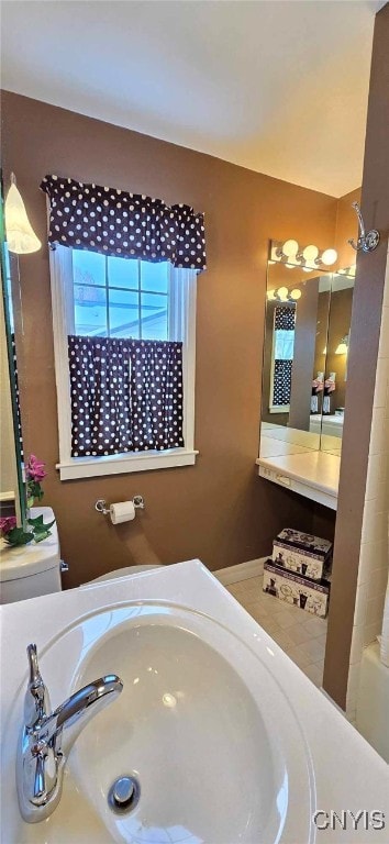 full bathroom with sink, toilet, tile patterned floors, and shower / washtub combination