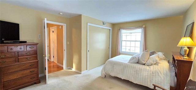 bedroom featuring light colored carpet and a closet