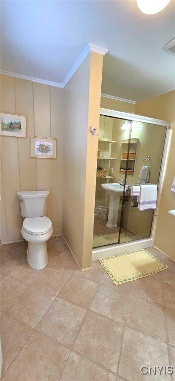 bathroom featuring sink, toilet, walk in shower, and crown molding