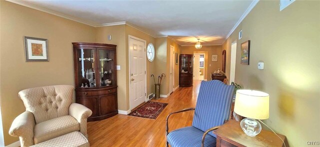 living area featuring hardwood / wood-style flooring and crown molding