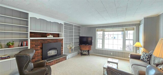 living room featuring built in shelves, wooden walls, a fireplace, and carpet floors