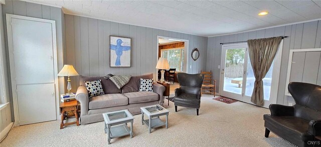 living room featuring light colored carpet and wood walls