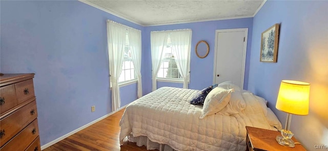 bedroom with wood-type flooring, ornamental molding, and a textured ceiling