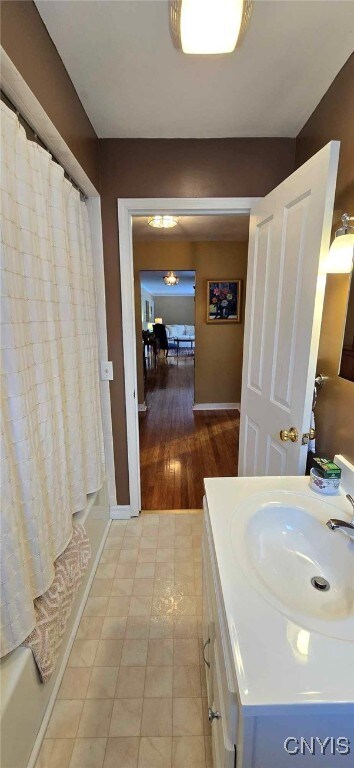 bathroom featuring shower / bath combo with shower curtain and vanity