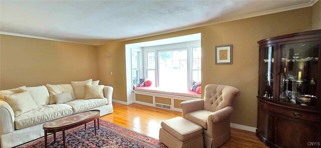 living room featuring light hardwood / wood-style floors and crown molding