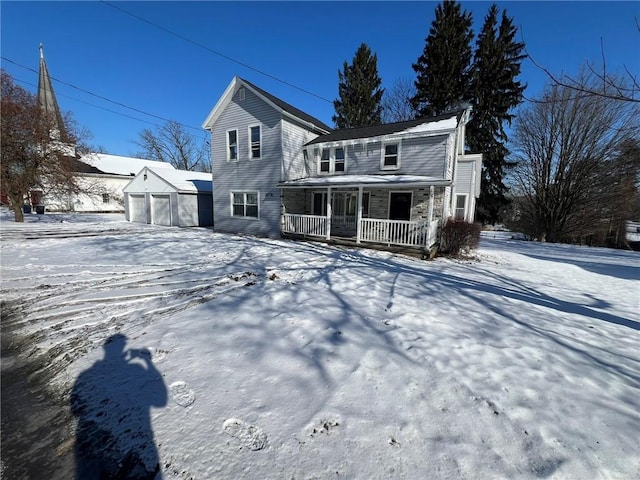 view of front of property featuring a porch, a garage, and an outbuilding