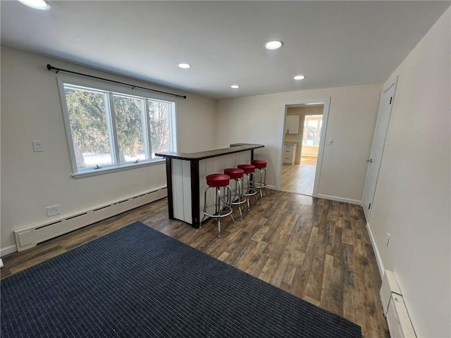 bar featuring a baseboard heating unit and dark wood-type flooring