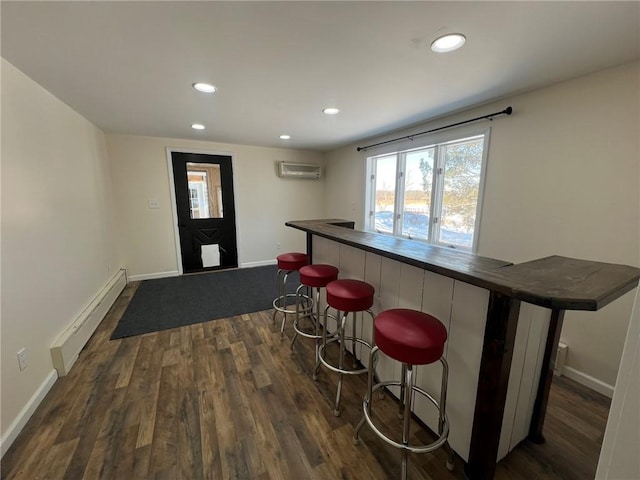 bar with dark hardwood / wood-style flooring, a baseboard heating unit, butcher block counters, and a wall mounted AC