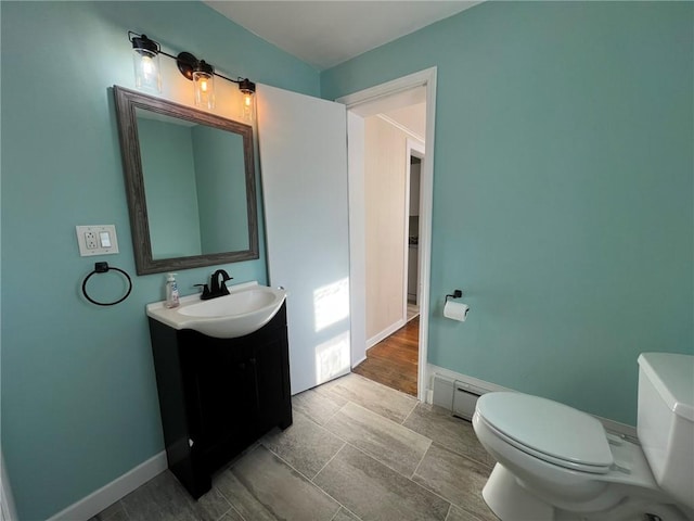 bathroom featuring a baseboard radiator, vanity, and toilet