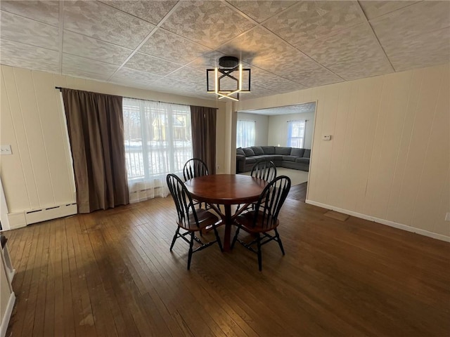 dining space featuring hardwood / wood-style flooring, a baseboard radiator, and a wealth of natural light