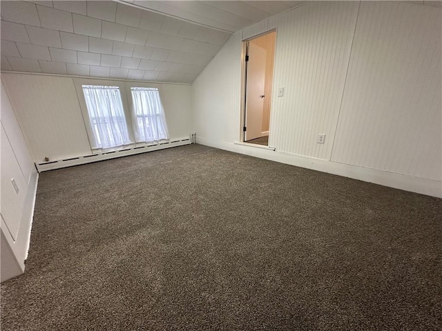 carpeted empty room with baseboard heating and vaulted ceiling