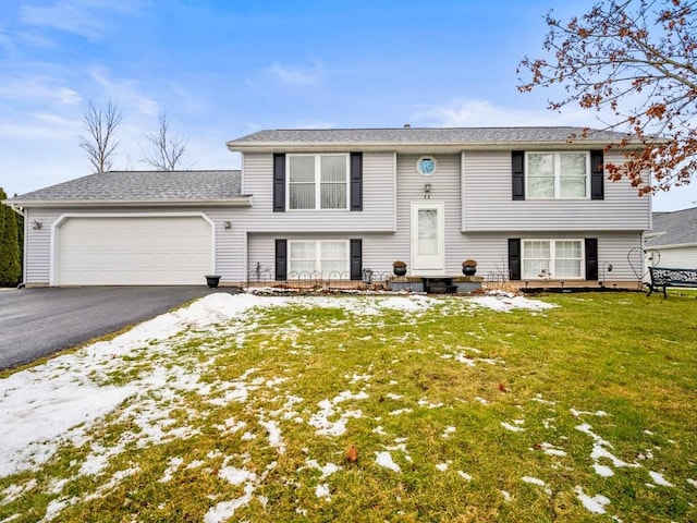 split foyer home with a garage and a front yard