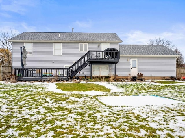 snow covered rear of property with a wooden deck