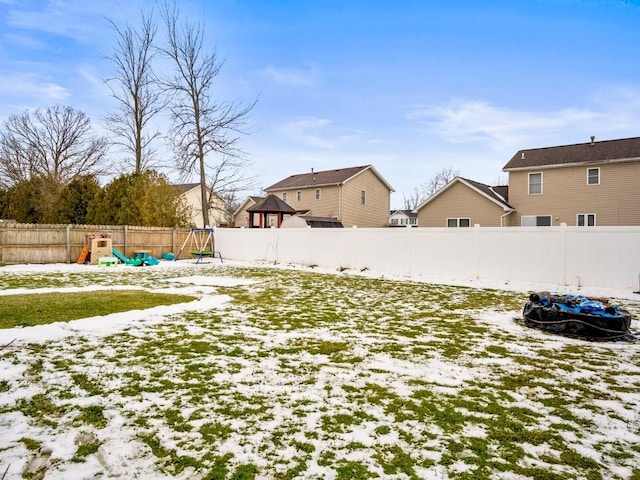 snowy yard featuring a playground