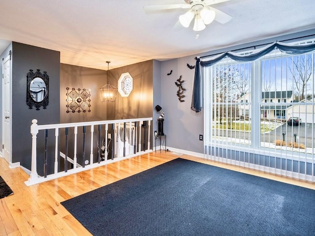 interior space featuring ceiling fan with notable chandelier and hardwood / wood-style floors