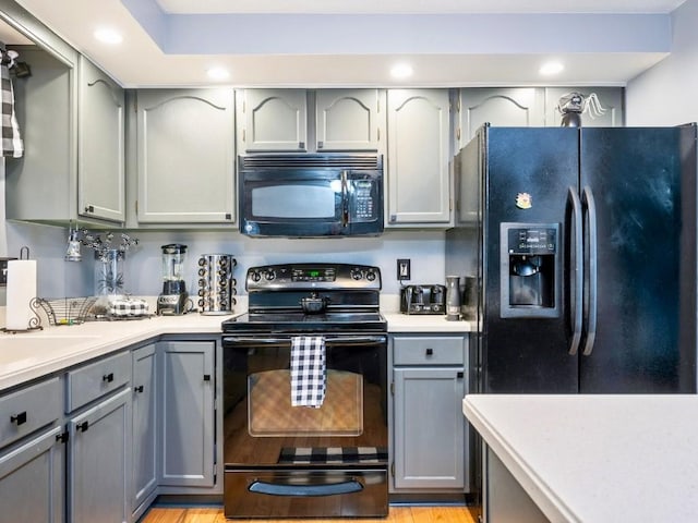 kitchen featuring sink, black appliances, and gray cabinetry