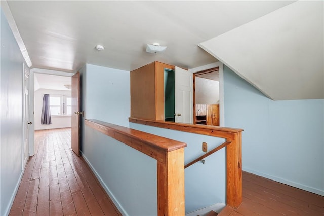 hall with hardwood / wood-style flooring and vaulted ceiling