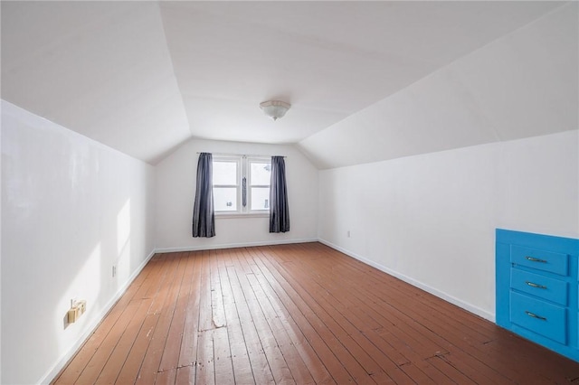 bonus room with wood-type flooring and vaulted ceiling