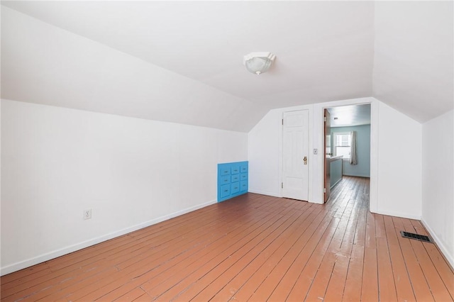 bonus room with hardwood / wood-style floors and vaulted ceiling