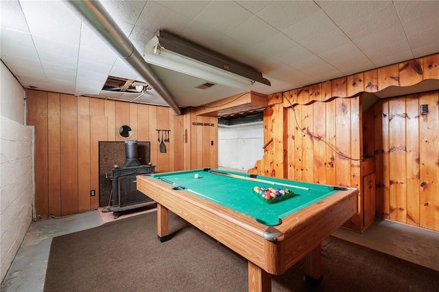 recreation room with a wood stove, concrete floors, wood walls, and pool table