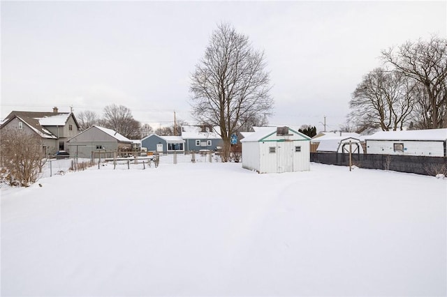 yard layered in snow featuring a storage shed