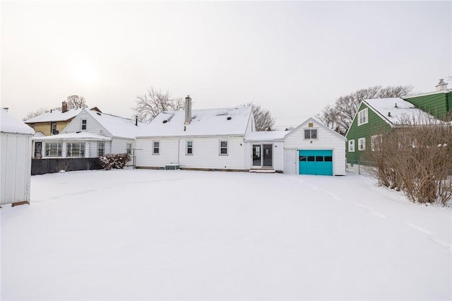 snow covered property with a garage