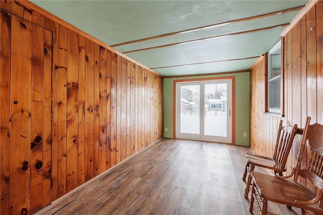 unfurnished room with wood walls, light hardwood / wood-style flooring, and ornamental molding