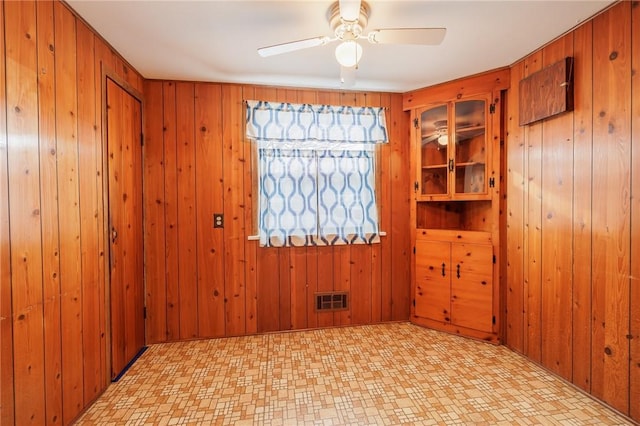 unfurnished room featuring wooden walls