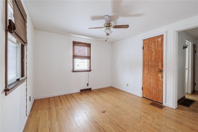 spare room with light wood-type flooring and ceiling fan