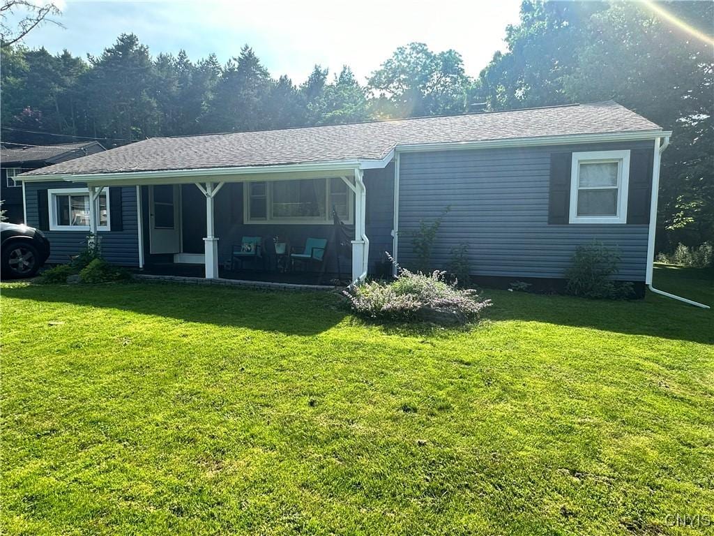 rear view of house featuring a porch and a yard